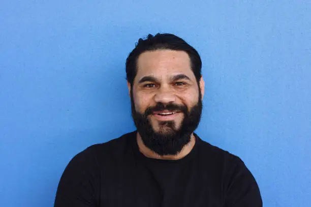 Portrait of Indigenous Australian man with great beard wearing a black shirt