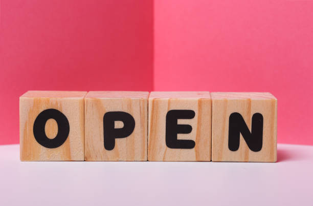 istock OPEN  word on wooden cubes on pink background 1417509783