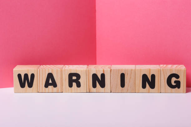 istock WARNING  word on wooden cubes 1417509796