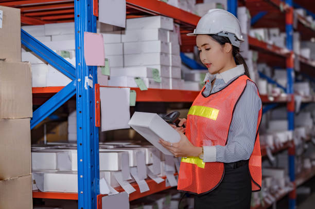 Female worker doing work and holding bar code scanner in warehouse. stock photo