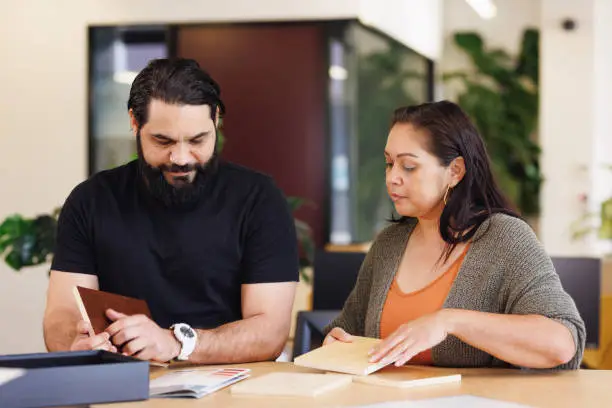 Male and female Aboriginal Australian designers collaborating in modern open workspace