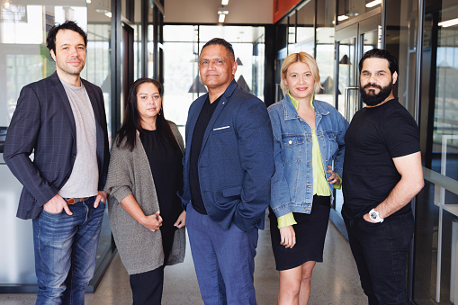 Team photo of five Aboriginal Australian creatives in modern workspace