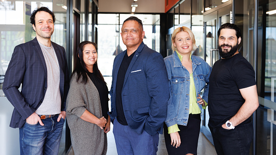 Team photo of five Aboriginal Australian creatives in modern workspace