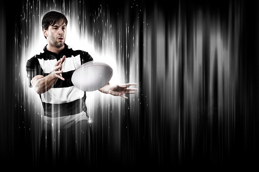 Rugby Player with a white uniform on a black and white background looking like a super hero.