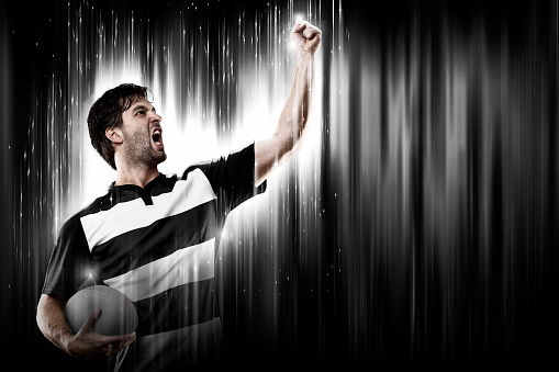 Rugby Player with a white uniform on a black and white background looking like a super hero.