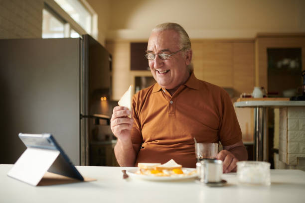 Senior Man Watching Comedy Show on Tablet