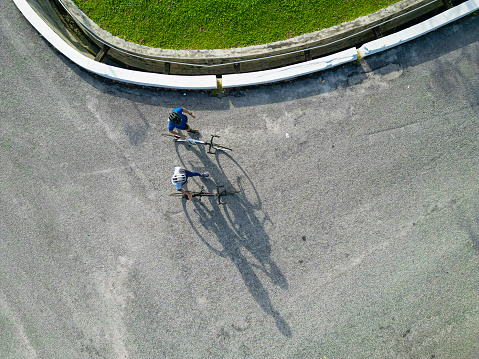 Asian Chinese couple cyclist taking a break walking with road biking cycle during weekend morning together