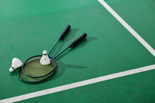 Shuttlecoks and Badminton Rackets Shuttlecoks and badminton rackets on green court floor playing badminton stock pictures, royalty-free photos & images