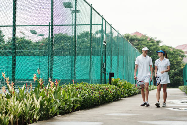 coppia che cammina verso il campo da tennis - tennis court love victory foto e immagini stock