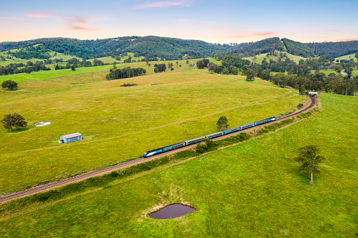 XPT Country link train Travelling north from Dungog NSW, towards Queensland Australia with a dusk sky.