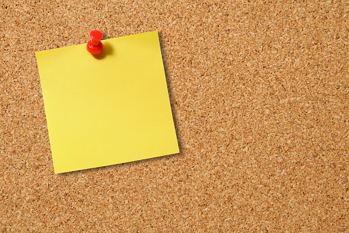 Cork board with four yellow sticky note, isolated on white with clipping path.