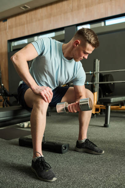 istock Man exercising with dumbbells in gym 1417533874