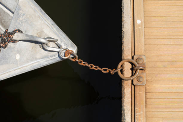 Rusted chain links, weathered rope and a ship's anchor lay on the wooden deck of an old commercial fishing trawler.