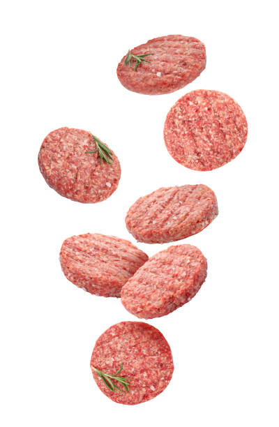 istock Fresh raw burger patties falling on white background 1417540132