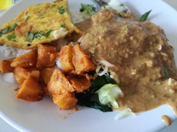 istock Nasi Pecel, Traditional Javanese rice dish, which is a portion of rice with a side dish of boiled vegetables plus peanut sauce and eggs. 1417543361