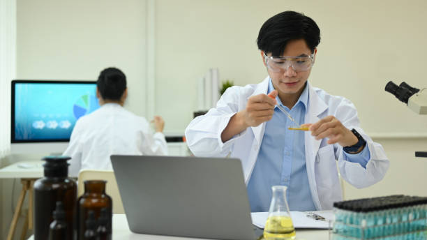 istock Microbiologist or researcher in white coat with petri dish examining samples in research laboratory. 1417545450