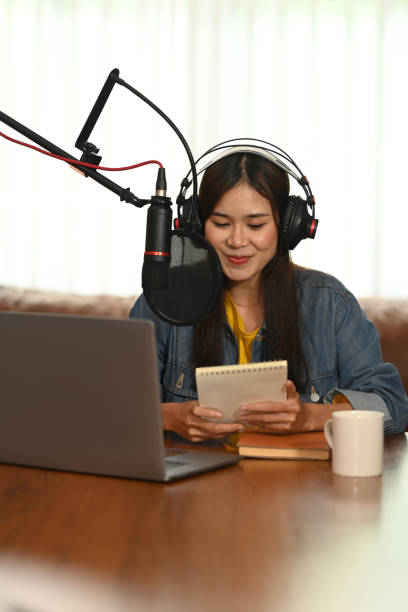 istock Asian content creator wearing headphone and talking through microphone for recording conversation for channel listeners. 1417547842