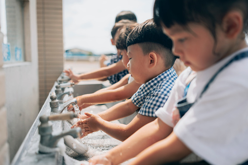 Students wash their hands with soap at school