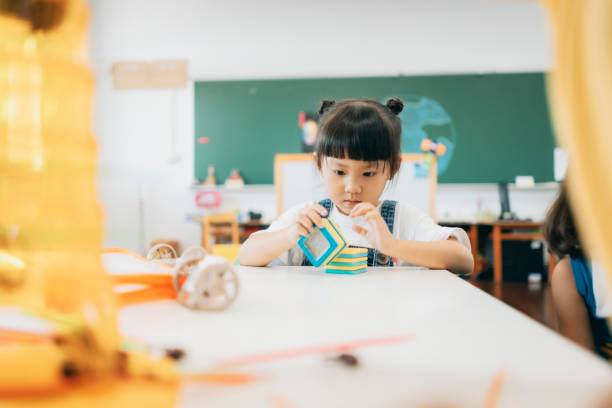 Preschool children playing with teaching aids in classroom