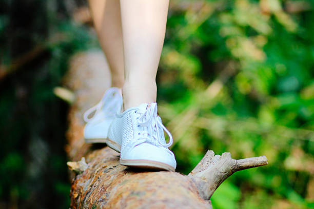 Girl goes on a log in the forest