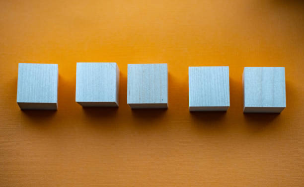 istock Five wooden cubes on orange background, mocap 1417552800