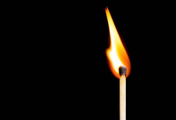 istock Close-up of a burning match isolated on black 1417554450