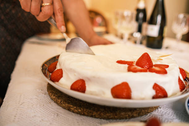 Strawberry dipped in white chocolate in focus, in the background is  kugelhopf cake