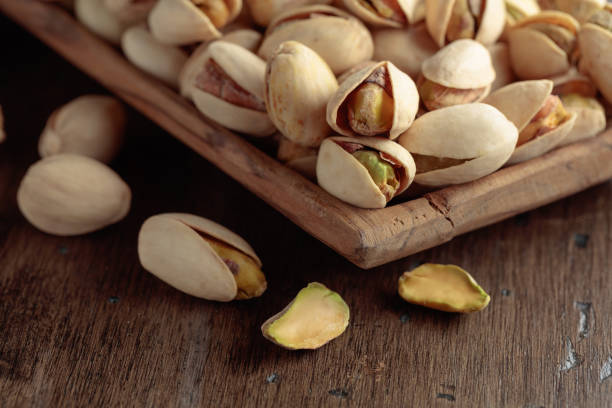 istock Salted pistachios on an old wooden table. 1417558047