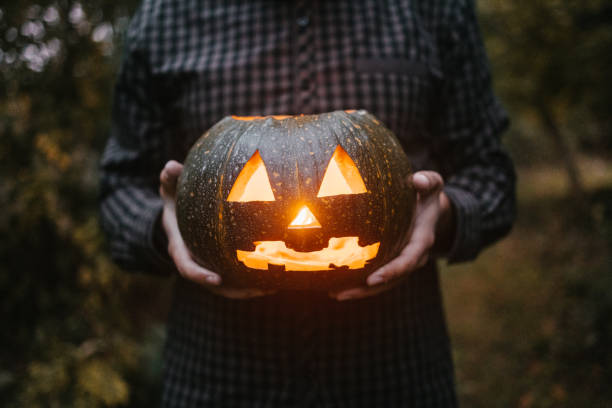 istock Unrecognizable man with carved pumpkin 1417560883