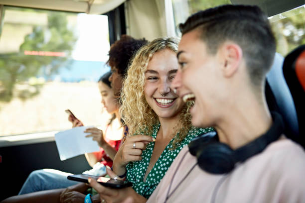 female friends laughing onboard vacation motor coach - bus coach bus travel tour bus imagens e fotografias de stock