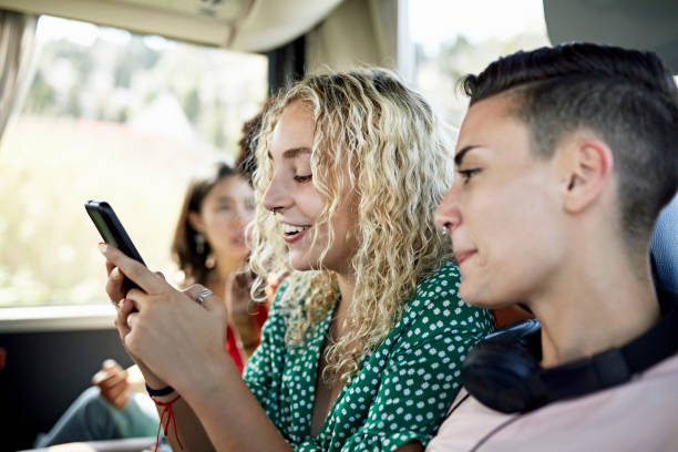 istock Young travelers using smart phone onboard motor coach 1417565167