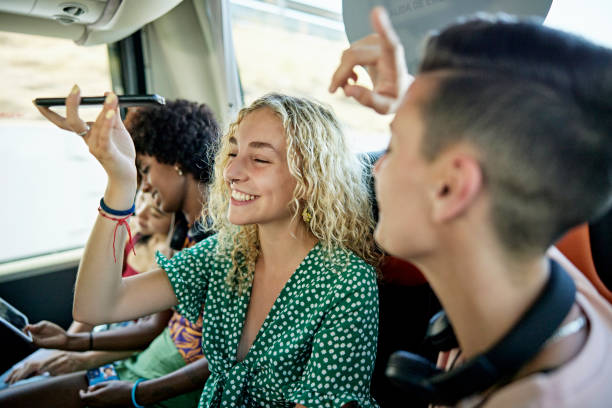 istock Laughing friends using technology to pass time on bus trip 1417565241