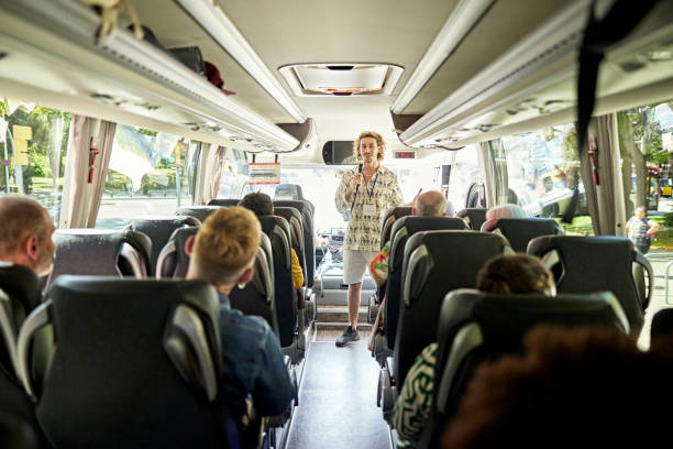 guía turístico en autocar hablando con los pasajeros con micrófono - front view bus photography day fotografías e imágenes de stock