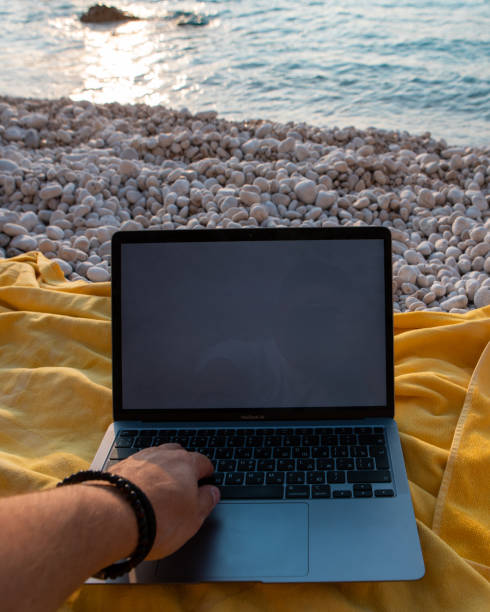 istock laptop with empty screen at sea beach freelance concept 1417565940