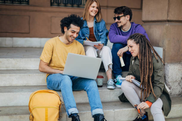 istock While writing a college project, a multiracial group of students sit on the steps and use a laptop 1417566064