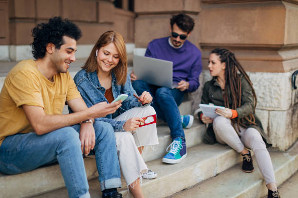istock A multiracial group of students hanging out and learning together while sitting on the stairs 1417566306