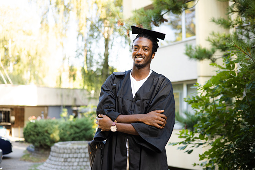 Portrait of a happy African American young man in graduation gown