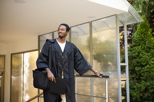 Portrait of a happy African American young man in graduation gown