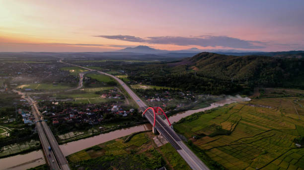 Aerial view of the Kalikuto Bridge, an Iconic Red Bridge at Trans Java Toll Road Aerial view of the Kalikuto Bridge, an Iconic Red Bridge at Trans Java Toll Road, Batang when sunrise. Central Java, Indonesia jawa timur stock pictures, royalty-free photos & images