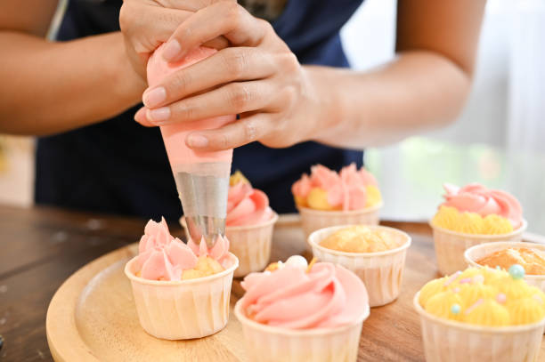 istock Woman using cream squeeze bag to decorating the cupcake, making cupcake 1417579743