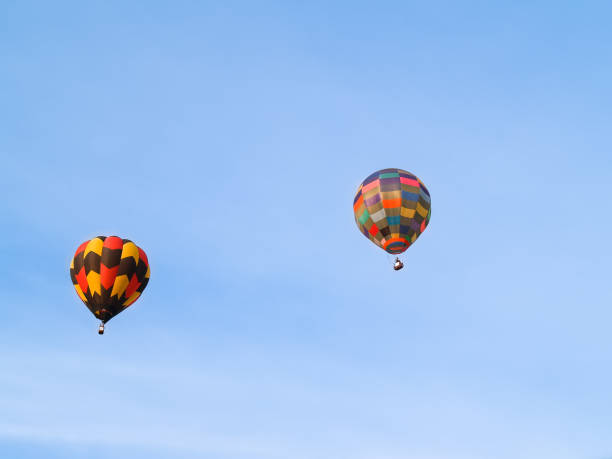 istock Highly coloured hot air balloons high up in blue sky. 1417580700