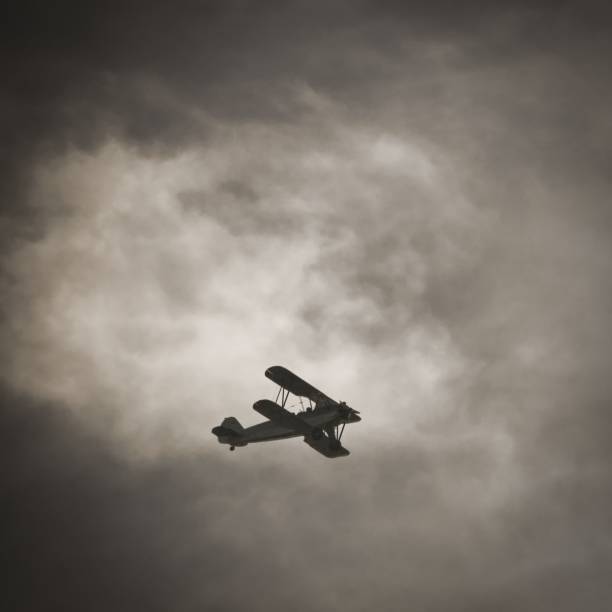 istock Retro airplane flying under cloudy sky 1417582398