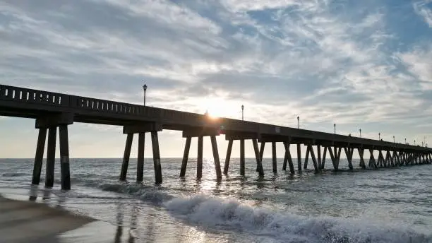 Photo of A low shot of a pier at sunrise
