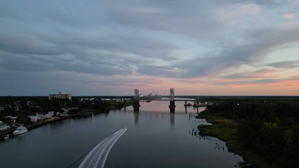 ein boot segelt einen fluss hinunter - cape fear stock-fotos und bilder