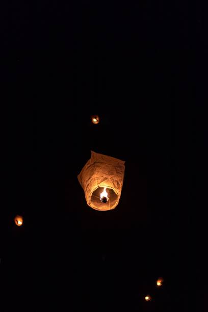 istock Vertical shot of lit sky lanterns in a dark sky 1417586546