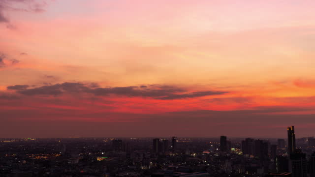 Atmosphere bright twilight sunset golden glow with clouds over buildings city landscape at Bangkok Thailand. Time lapse 4k skyline in the evening sundown architecture on nature background.