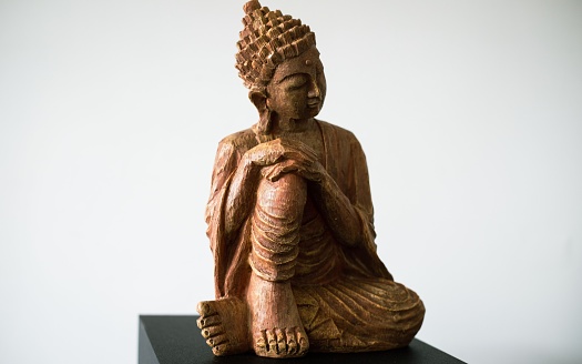 A wooden figurine of spiritual teacher Gautama Buddha in its full size