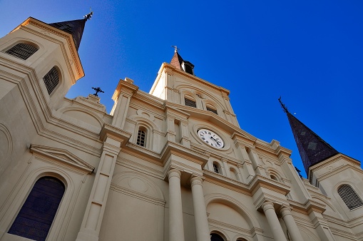 A low-angle view of St. Louis Catherdral in New Orleans, Louisiana, with a blue sky in the background