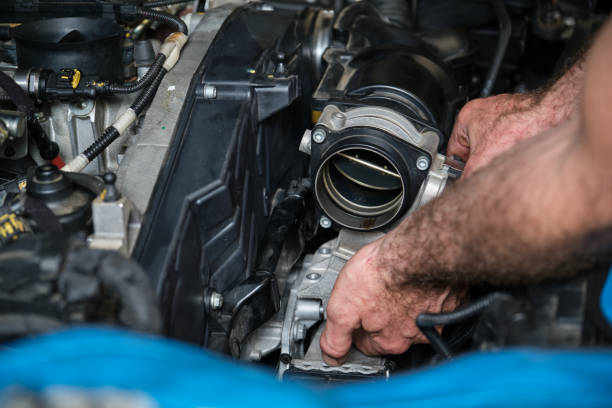 istock Car mechanic hands replacing engine throttle body. 1417597842
