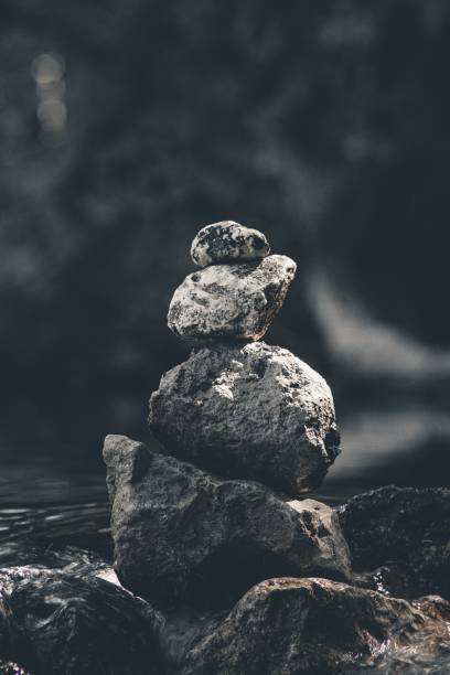 istock Vertical shot of huge, sharp rocks balanced neatly atop one another by a stream in the wilderness 1417598039